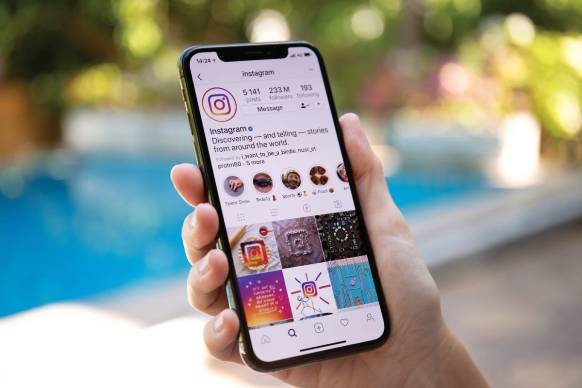 personne qui tient dans sa main un téléphone avec l'application Instagram ouverte